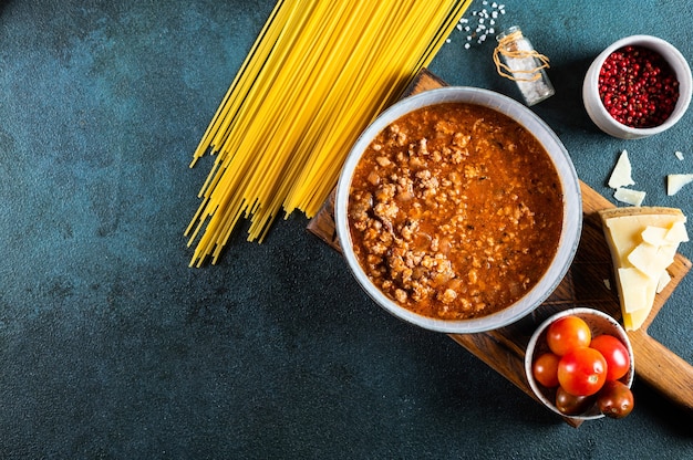 Zutaten für Spaghetti Bolognese auf dunklem Hintergrund. Rohe Nudeln Bolognese. Pasta-Flatlay. Italienische Bolognese. Inhaltsstoffe. Pasta-Draufsicht
