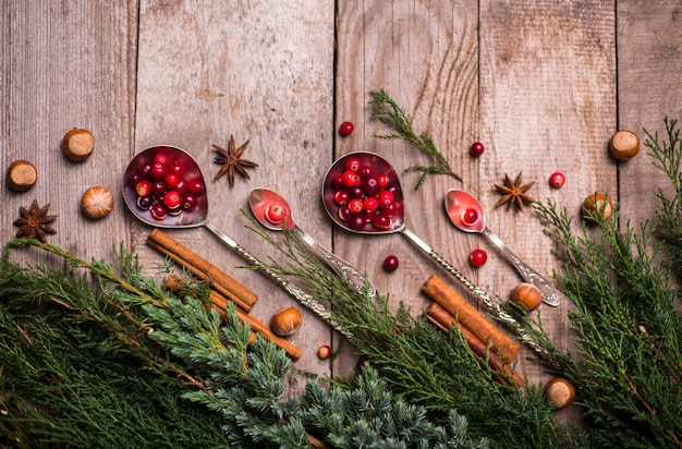 Zutaten für weihnachten, winterplätzchen backen. lebkuchen, obstkuchen, saisonale getränke. moosbeeren, getrocknete orangen, zimt, gewürze auf einem holztisch, draufsicht des kopienraumes.