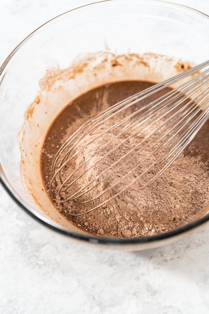 Zutaten in einer Rührschüssel aus Glas mischen, um S'mores Cupcakes zu backen.