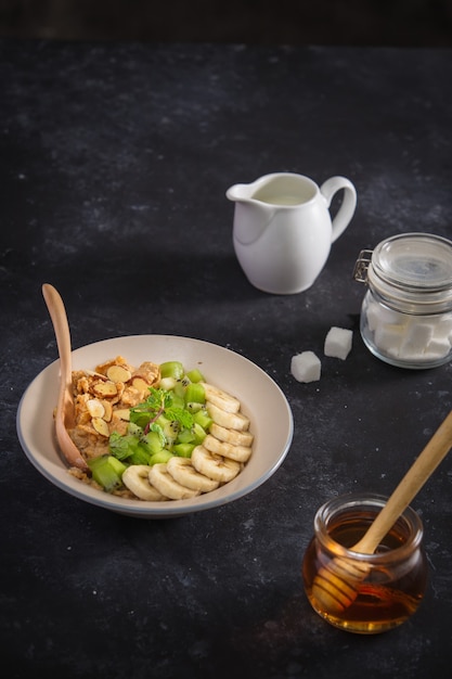 Zutaten leckeres gesundes Frühstück zum Kochen mit Milch- und Haferflocken, Banane, Kiwi auf rosa Hintergrund