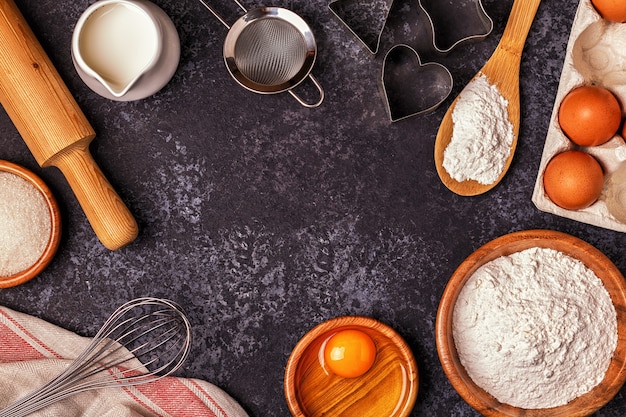 Zutaten zum Backen - Mehl, Holzlöffel, Nudelholz, Eier. Ansicht von oben, Kopienraum.