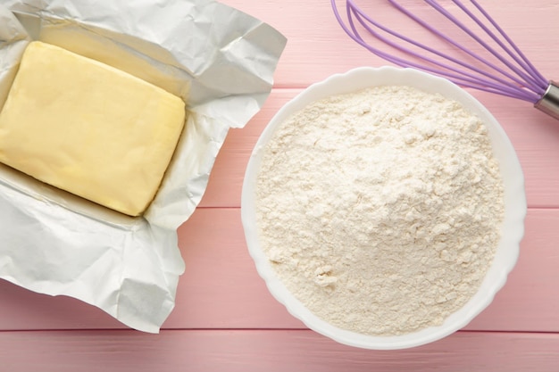 Zutaten zum Backen oder Kochen Ei Mehl Nudelholz Buttermilch auf einem rosafarbenen Holzhintergrund Cookie Pie oder Kuchenrezept