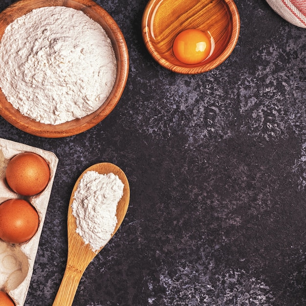 Zutaten zum Backen von Mehl, Holzlöffel, Nudelholz, Eiern