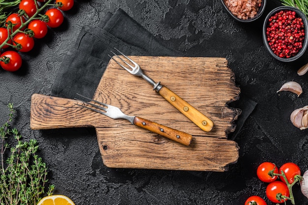 Zutaten zum Kochen und leeres Schneidebrett auf altem Holztisch Kochen von Speisen und gesunde Ernährung Hintergrund Schwarzer Hintergrund Draufsicht Kopieren Sie Platz