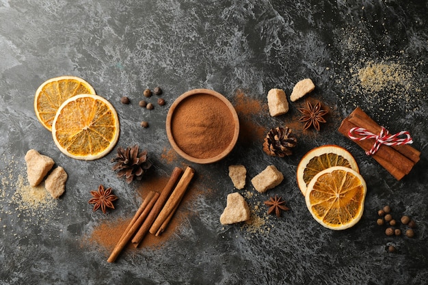 Zutaten zum Kochen von Glühwein auf schwarzem rauchigem Hintergrund