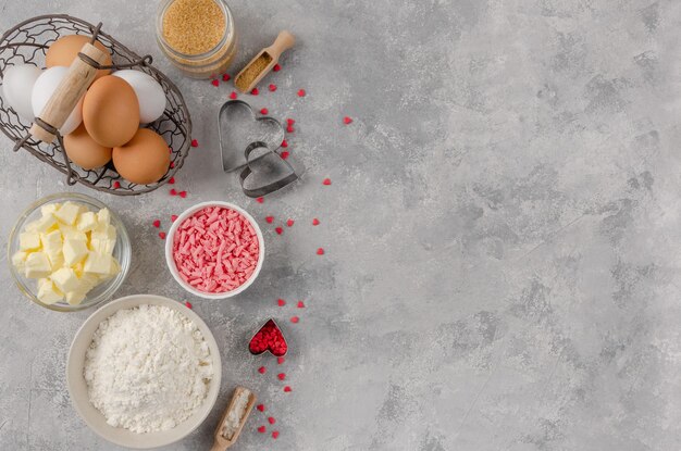 Zutaten zum Kochen von Keksen zum Valentinstag Mehl Butter Eier Schokolade und Zuckerherzen