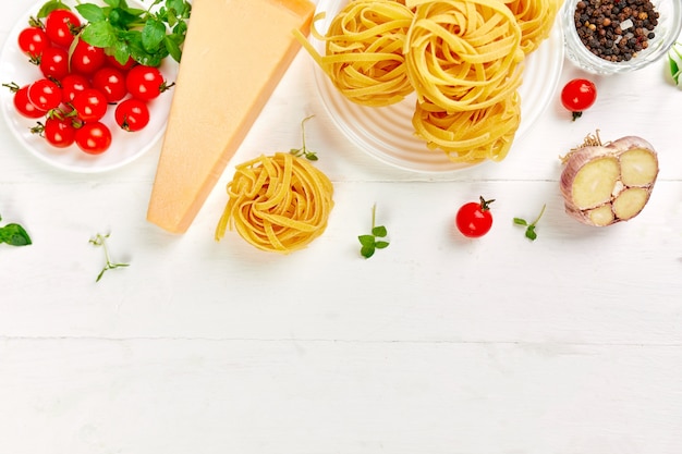 Zutaten zum Kochen von Pasta Tagliatelle, Tomaten, Knoblauch, Basilikum, Parmesan