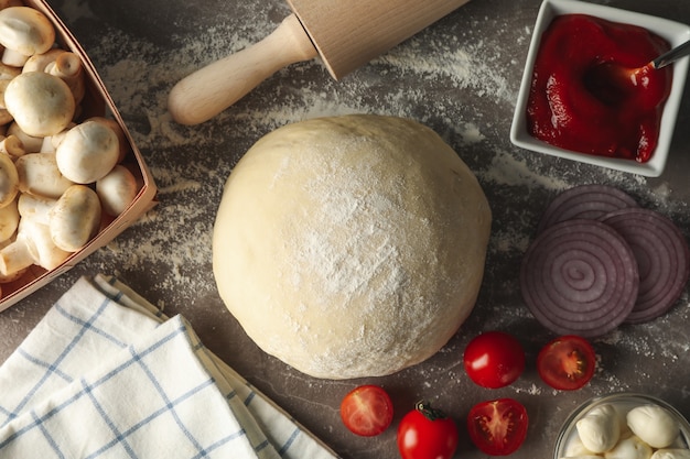 Zutaten zum Kochen von Pizza auf grauem Hintergrund