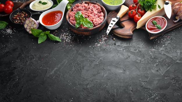 Zutaten zum Kochen von Sauce Bolognese Auf schwarzem Hintergrund Ansicht von oben Freier Platz für Ihren Text