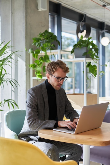 Zuversichtlich erfolgreicher Jungunternehmer Unternehmer Programmierer mit Laptop arbeitet an neuer Software