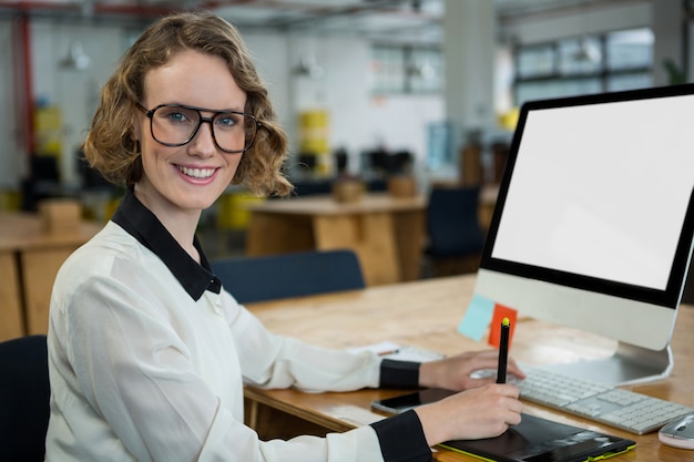 Zuversichtlich Frau, die am Schreibtisch im Büro sitzt