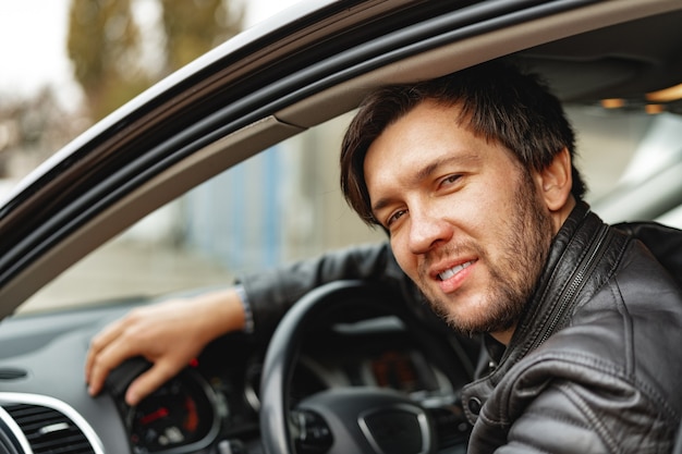 Zuversichtlich junger Mann, der in einem Auto sitzt