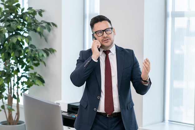 Zuversichtlicher Makler in der Formalwear-Beratung des Kunden am Telefon