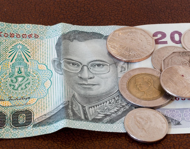 Zwanzig-Baht-Note aus Thailand mit Münzen