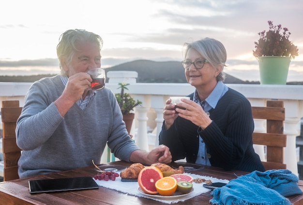 Zwei ältere Leute, Mann und Frau, die das Frühstück auf der Terrasse genießen?