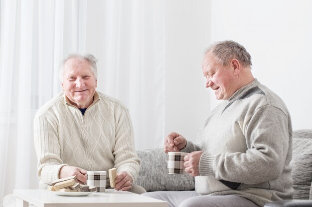 Zwei ältere Männer mit Tasse Tee drinnen