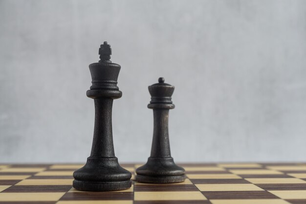 Zwei ältere schwarze Schachfiguren auf dem Brett