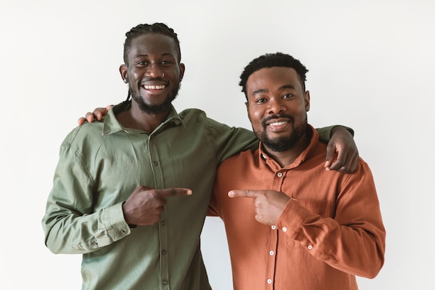 Zwei afrikanische Männer zeigen mit dem Finger auf einen anderen weißen Hintergrund