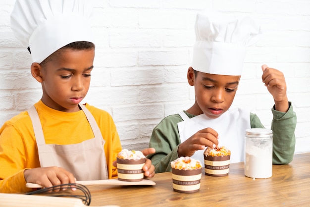 Zwei Afroamerikaner-Bruderkinder gekleidet als Chef