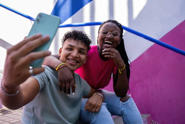 Zwei afroamerikanische Teenager fotografieren mit dem Handy