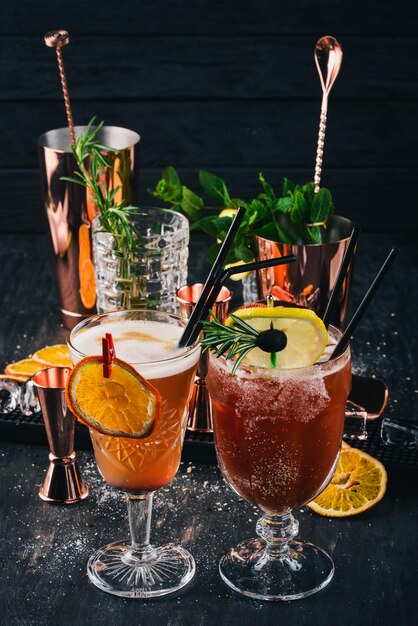 Zwei alkoholische Cocktails Mai Tai Bloody Mary auf schwarzem Holzhintergrund