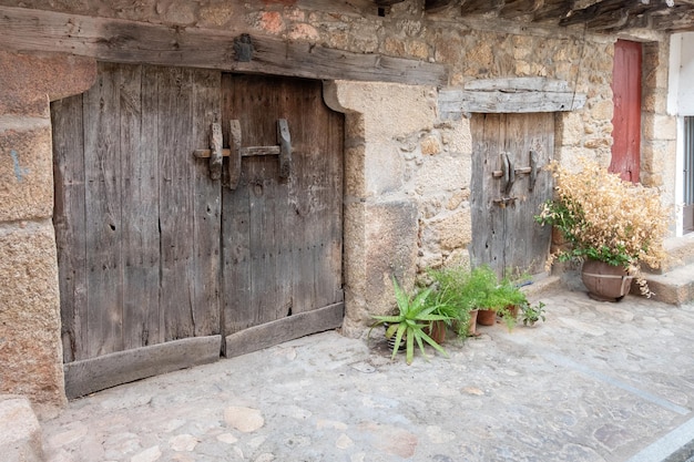Zwei alte zweiblättrige Holztüren in Stein- und Lehmkonstruktionen