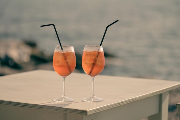 Zwei Aperol Spritz-Cocktails auf dem Tisch vor dem Meereshintergrund