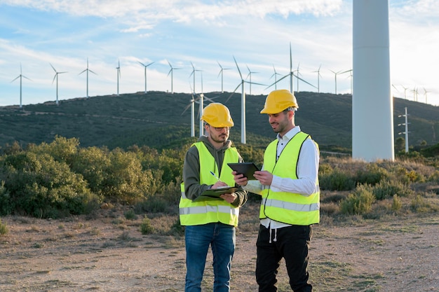 Zwei Arbeiter arbeiten mit Warnwesten in einem Windpark