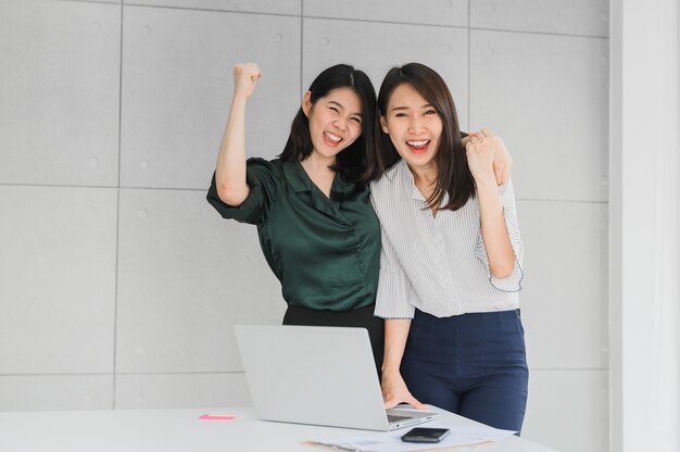 Zwei asiatische Freundinnen feiern Erfolg