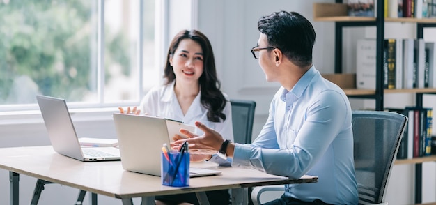 Zwei asiatische Geschäftsleute, die im Büro arbeiten