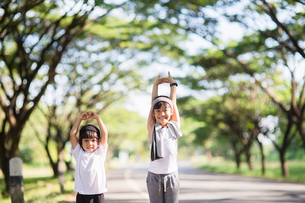 Zwei asiatische kleine Mädchen, die Spaß haben und zusammen im Park im Vintage-Farbton laufen