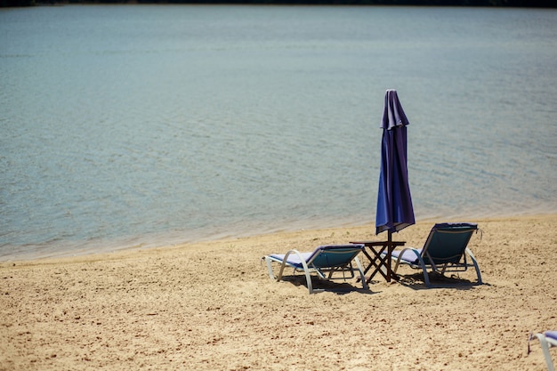 Zwei Aufenthaltsräume mit Sonnenschirm am Strand