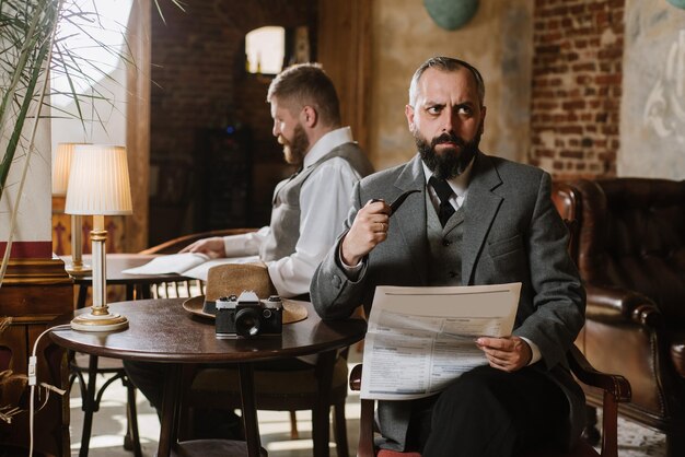 Zwei bärtige Männer in altmodischen Anzügen unterhalten sich oder diskutieren etwas im Restaurant