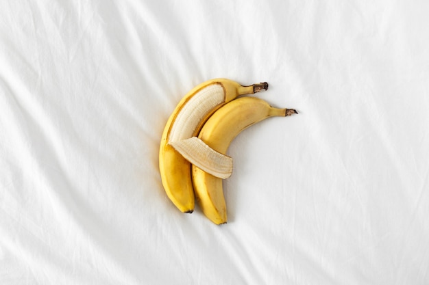 Zwei Bananen liegen nebeneinander und umarmen sich wie Menschen.