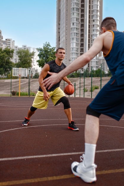 Zwei Basketballspieler trainieren Taktiken auf dem Platz im Freien