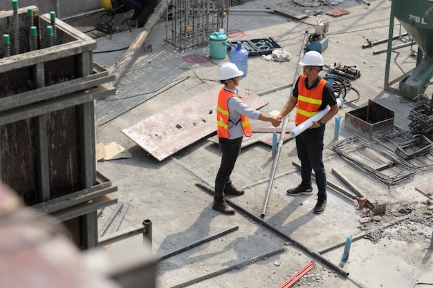 Zwei Bauingenieure geben sich auf der Baustelle die Hand