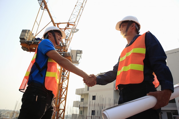 Foto zwei bauingenieure geben sich auf der baustelle die hand