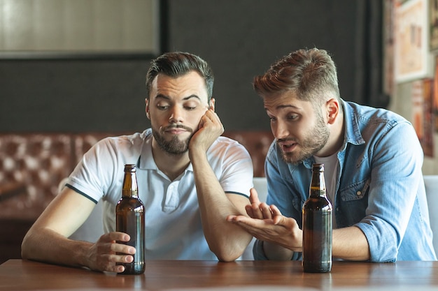 Foto zwei betrunkene freunde unterhalten sich im café