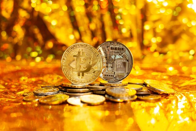 Zwei Bitcoins auf einem Stapel Münzen auf goldenem Hintergrund und Bokeh