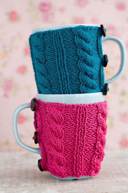 Zwei blaue Tassen im blauen und rosafarbenen Pullover