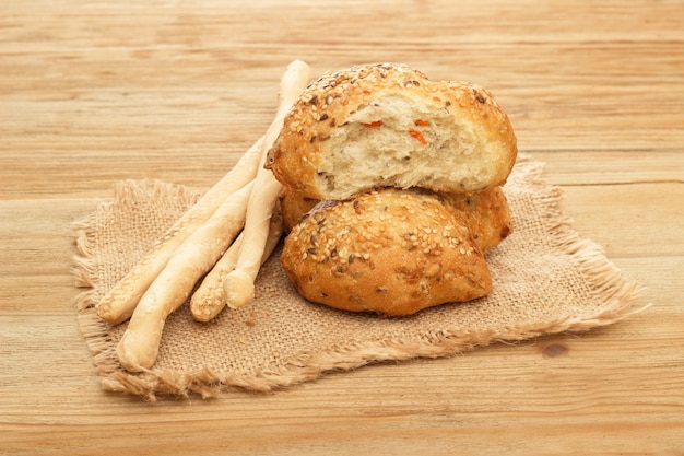 Zwei Brötchen mit Sesam und Brotstangen liegen auf der Entlassung im Hintergrund