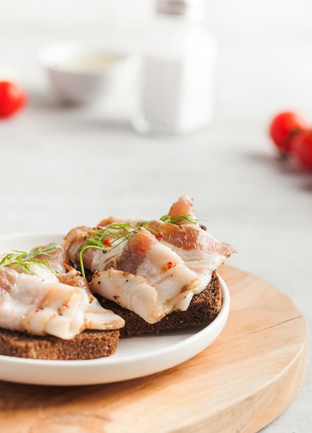 Zwei Brotscheiben mit gesalzenem Schweinespeck oder Schmalz traditionelle Snacks zu ukrainischem Borschtsch