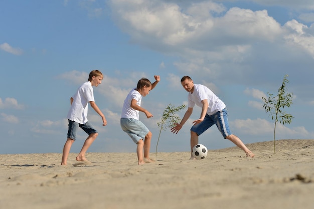 Zwei Brüder, die mit Vater Fußball spielen