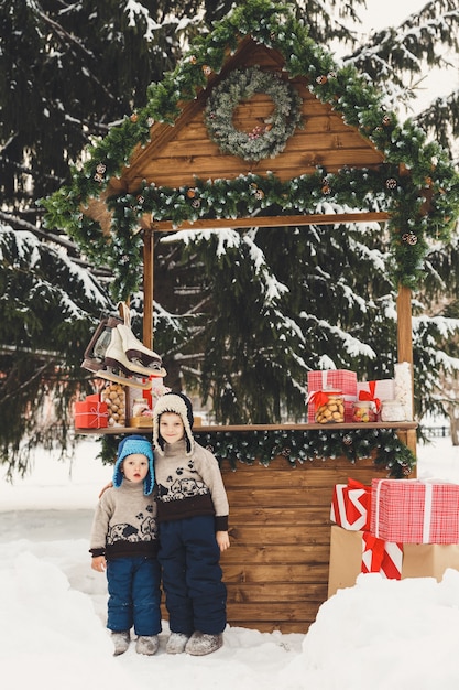 Zwei Brüder Jungen am Weihnachtsmarkt Candy Shop im Freien