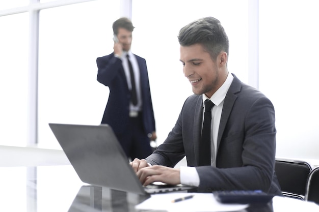 Zwei Buchhalter lösen wichtige Fragen Der eine benutzt einen Laptop, der zweite telefoniert