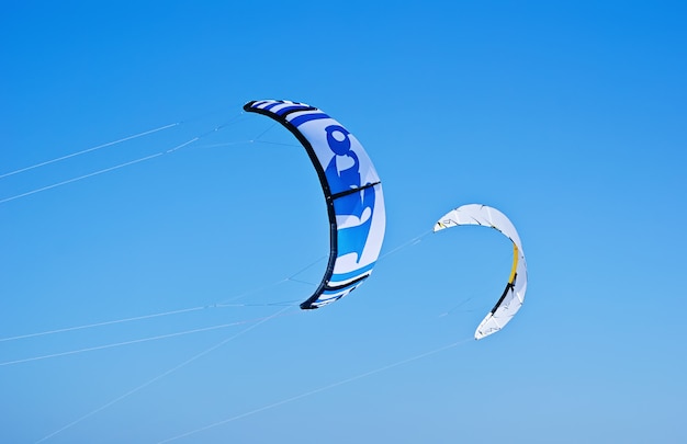 Zwei bunte Drachen von Kiteboarding fliegen in den blauen Himmel