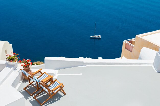 Zwei Chaiselongues auf der Terrasse mit Meerblick. Santorin, Griechenland