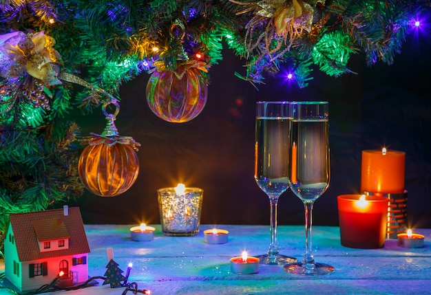 Zwei Champagnergläser mit Kerzen und Weihnachtsbaum