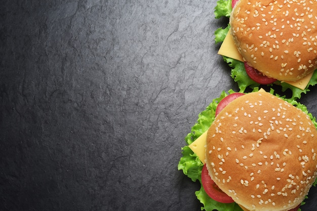 Foto zwei cheeseburger auf schwarzer schieferwand