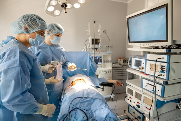 Zwei Chirurgen operieren einen Patienten mit Endoskopen